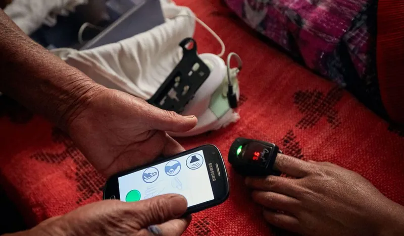 A health worker uses a smartphone application during a home visit.